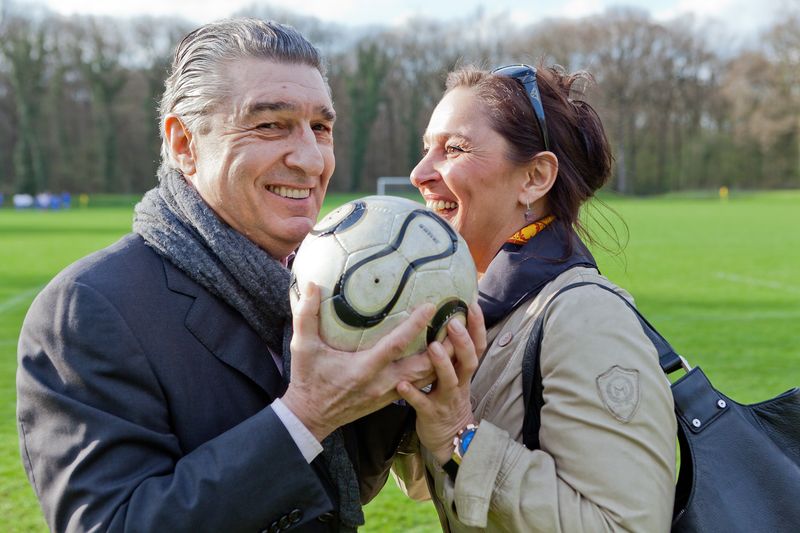 Ein Mann und eine Frau halten einen Fußball